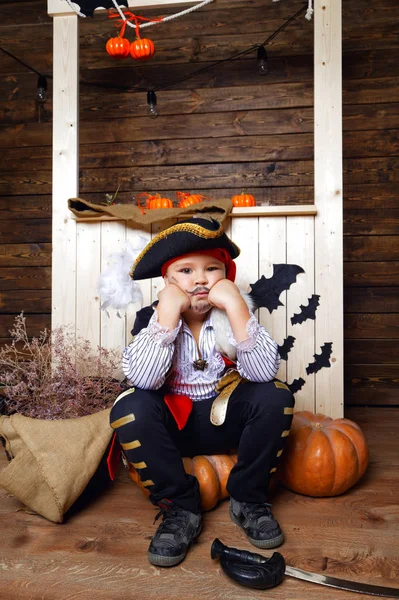 Chico divertido en traje de pirata en el estudio con paisajes para Halloween — Foto de Stock