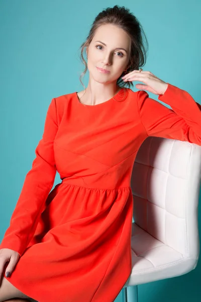 Chica en un vestido rojo sobre un fondo azul —  Fotos de Stock