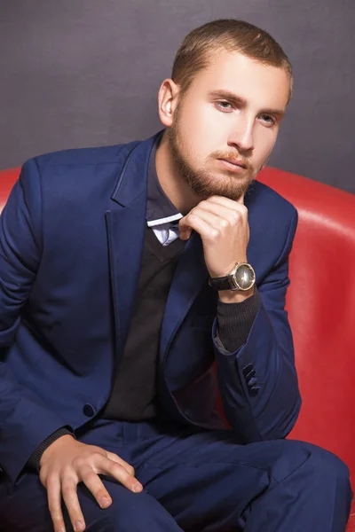 Serious young man in a suit on the sofa — Stock Photo, Image