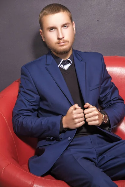 Serious young man in a suit on the sofa — Stock Photo, Image