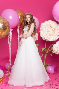 genç genç kız pembe bir arka plan üzerinde stüdyoda. Bir prenses gibi