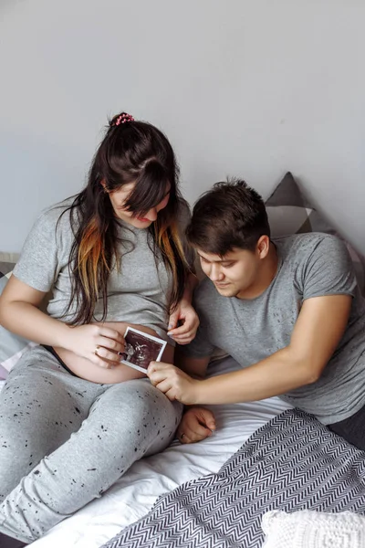 Jovem feliz casal grávida no quarto em casa — Fotografia de Stock