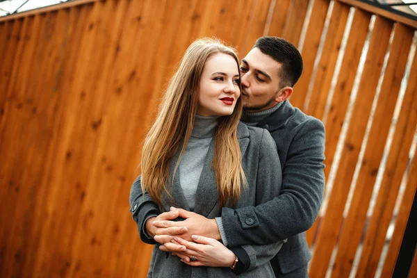 Loving couple in a coat walk along the street — Stock Photo, Image