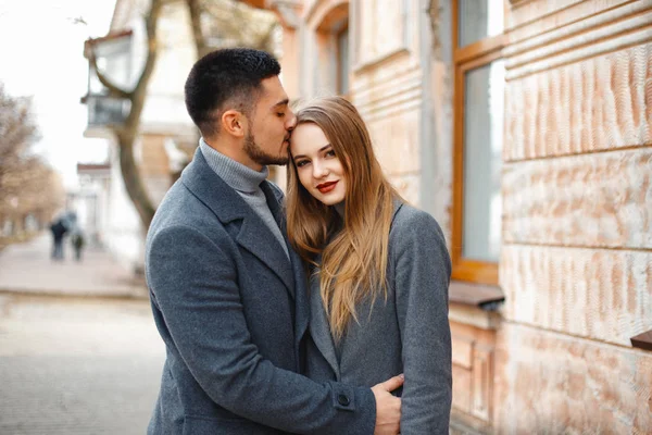 Casal amoroso em um passeio casaco ao longo da rua — Fotografia de Stock