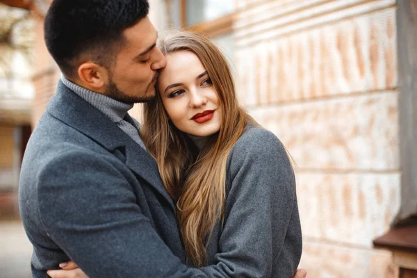 Pareja cariñosa en un abrigo caminar por la calle —  Fotos de Stock