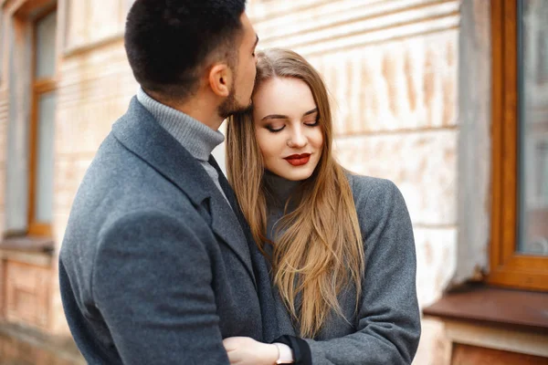 Liefdevol echtpaar in een jas lopen langs de straat — Stockfoto