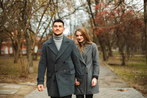 Casal amoroso em um passeio casaco ao longo da rua — Fotografia de Stock