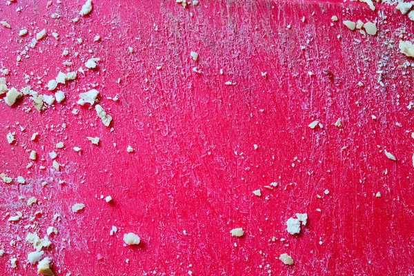Kruimels in een geraspte rode oppervlak — Stockfoto