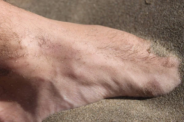 Männlicher Fuß im Sand — Stockfoto