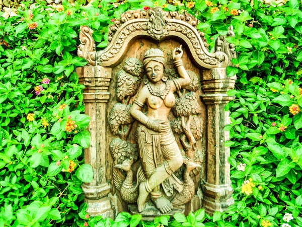 Ангел древней древесины кривой стенд в саду цветов лантана — стоковое фото