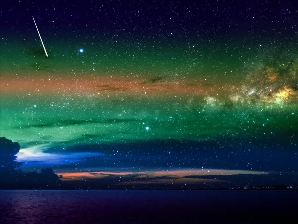 Meteoros caem sobre nuvens escuras e céu noturno sobre a cidade — Fotografia de Stock