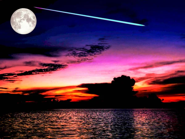 Повний метеорит місяця падає з космічного неба на морі під час заходу сонця — стокове фото