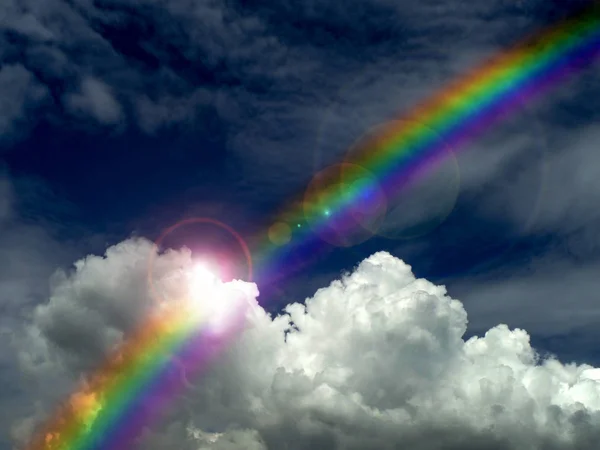 Luce del sole che splende su nuvole scure e arcobaleno dopo la caduta della pioggia — Foto Stock