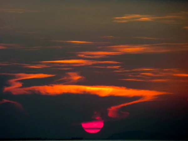 Half sunset on sky line in the sea dark cloud — Stock Photo, Image