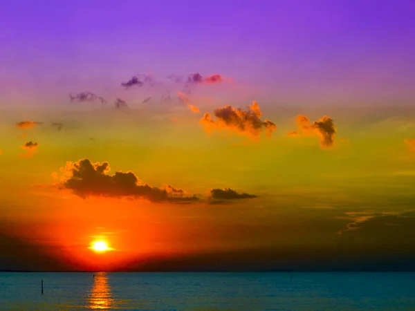 Luz solar do pôr do sol no mar à noite e céu roxo — Fotografia de Stock