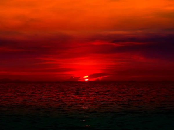 Sunset last light of sun on horizontal line over red sky and oce — Stock Photo, Image