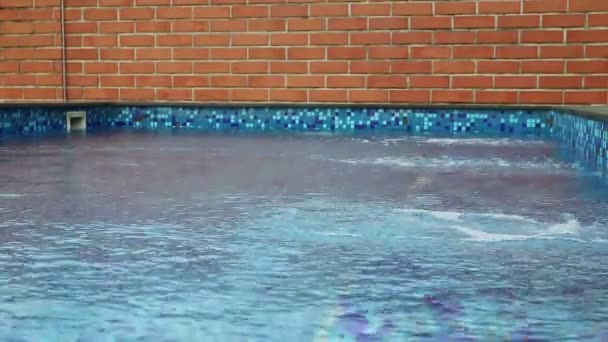 El agua se ha movido por el viento en la piscina pared de ladrillo — Vídeos de Stock