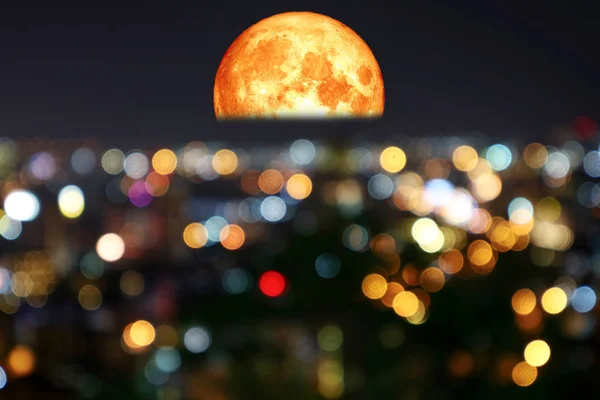 Halva blod måne färgglada av oskärpa natt ljus över staden — Stockfoto