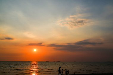 siluet adam ve çocuk oynamak plaj ve günbatımı