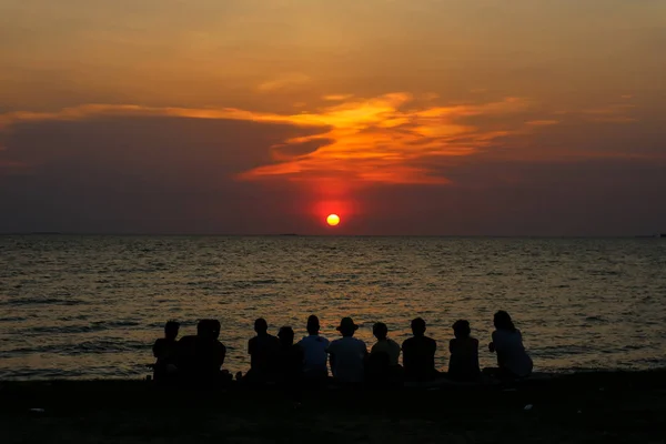 Silhouet familie kijken avondrood op het strand — Stockfoto
