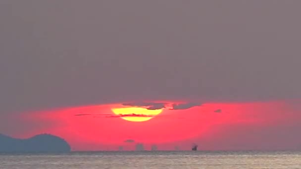 Zoom a sol Omega y puesta de sol en el cielo naranja nube de color rojo oscuro y barco de pesca que pasa el lapso de tiempo — Vídeos de Stock