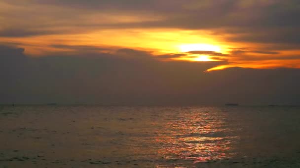 Відображення заходу сонця на поверхні води моря і темної хмари на небі — стокове відео