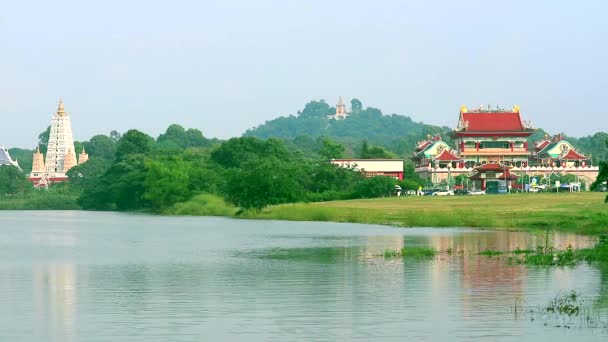 Templos budistas estilo chinês e pagodes estão situados em um lago no meio de um vale — Vídeo de Stock