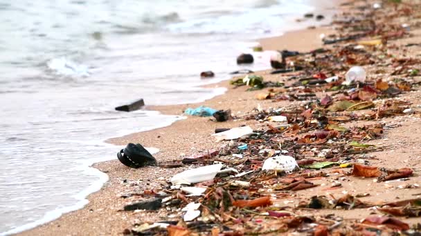 Naplemente a tengeren műanyag gumival és hulladék marad a tengerparton, és hullámok fújta őket a tengerbe1 — Stock videók