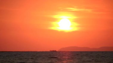 Gün batımı ve deniz yüzeyindeki güneş ışığının yansıması ve adaya geri dönmek.