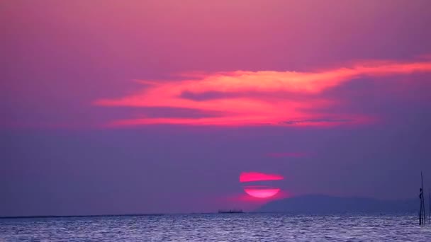 Solnedgång och lila moln på himlen över havet och ytan liten våg rör sig — Stockvideo