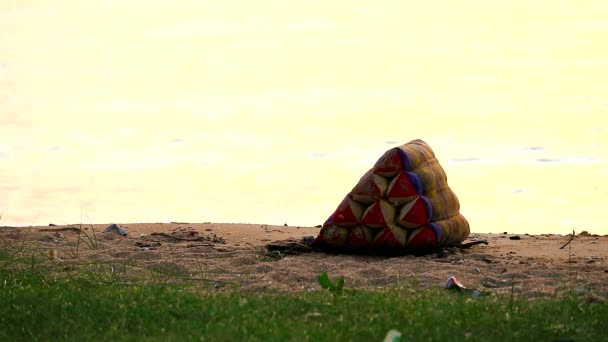 Poduszki wyrzucono za burtę i zabrano na plażę, a zachód słońca oświetlono. — Wideo stockowe