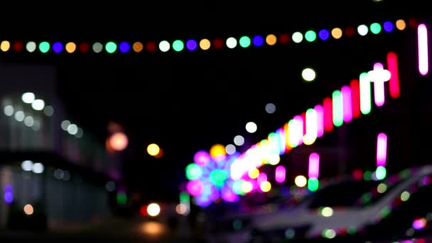 Barevné rozmazané neonové světlo a silueta vozidla v noci na trhu veletrhu — Stock video