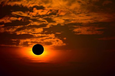 Siluet turuncu bulutun üzerinde kısmi güneş tutulması fenomeni