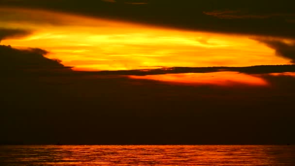 海の向こうの夜空にオレンジ色の雲の暗い黄金の夕日のシルエット — ストック動画