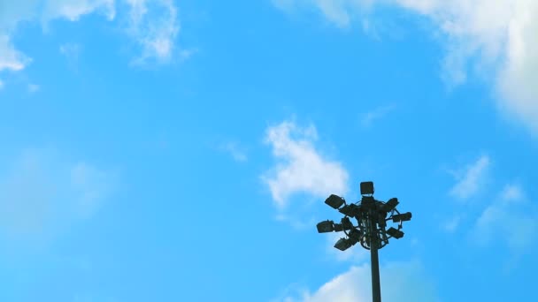 Чистое голубое небо и белое облако кучи движущееся время истекает на спортивном световом столбе — стоковое видео