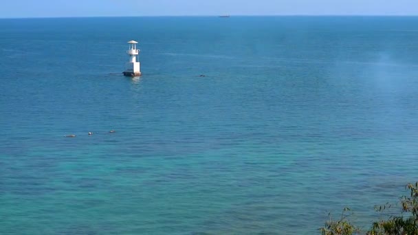 White lighthouse is surrounded by coral reefs in the blue green ocean — Stock Video