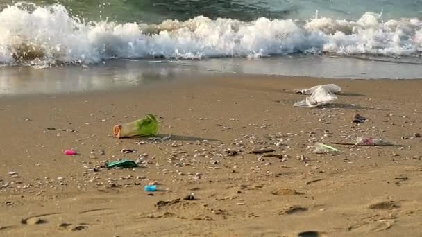 Taza de plástico y residuos en la playa y las olas soplaron en el mar — Vídeos de Stock