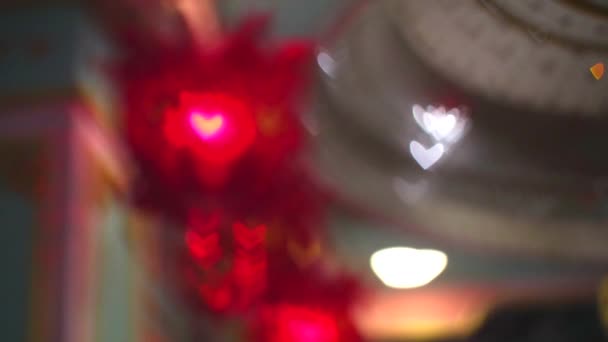 Раскатывающиеся фонари размывают легкое сердце висит на клетке в день Святого Валентина — стоковое видео
