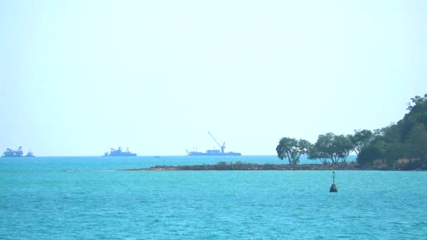 Вантажний корабель на фоні горизонту моря і острова — стокове відео