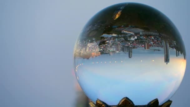 A város fejjel lefelé van, amikor a napnyugta egy kristálygömbben a fény visszaverődése miatt — Stock videók