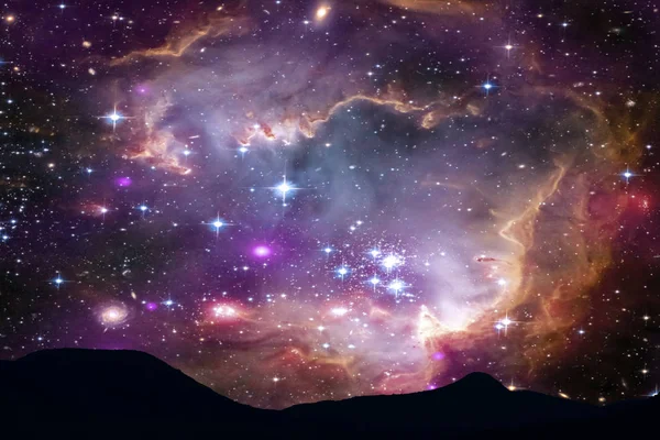 Туманність у галактиці над силуетом на гірському нічному небі. — стокове фото