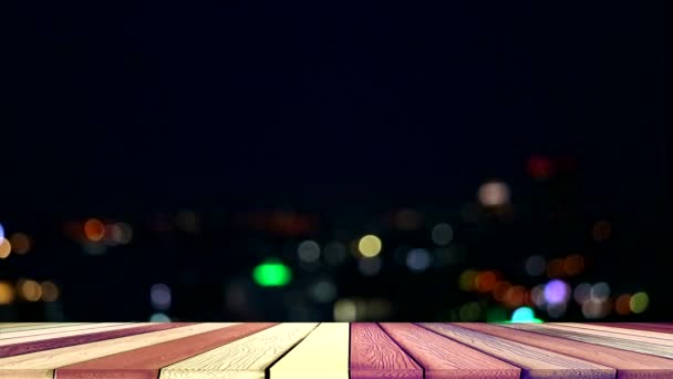 Верхний деревянный стол и размытый ночной свет города — стоковое видео