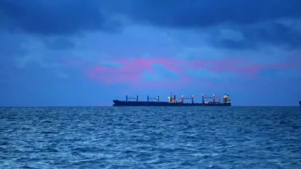 Sonnenuntergang dunkel Himmel rote Gewitterwolke bewegt sich auf See und Silhouette Frachtschiff und Welle auf dem Wasser — Stockvideo