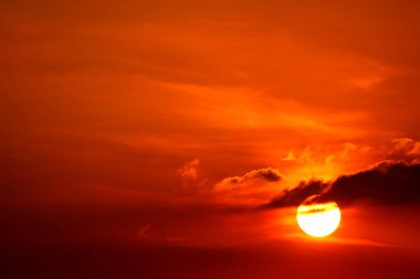 Kızıl gökyüzünde gün batımı ve güneş ışınları siluet akşam bulutu