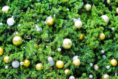 Noel ağacının bir kısmında yeşil yapraklar var ve Noel festivalini kutlamak için çeşitli eşyalarla süslenmiş.