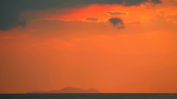 Tramonto rosso sulla superficie dell'acqua dell'isola di mare e silhouette e nuvola rossa sul cielo — Video Stock