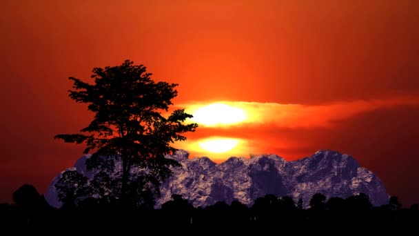 Pôr do sol céu vermelho e lua vermelha super subir de volta nuvem e silhueta montanha e árvores — Vídeo de Stock