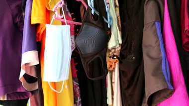 Tek kullanımlık beyaz yüz maskesi ve askıda yıkanabilir siyah renk asılı.