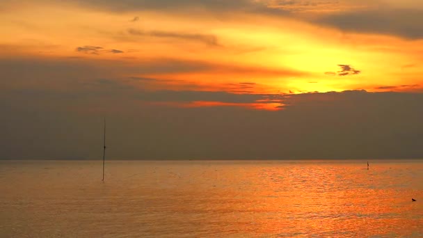 Günbatımı turuncu gökyüzü ve denizin üzerinde hareket eden koyu sarı bulut — Stok video