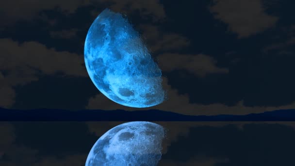 Félig kék hold emelkedik a sötét égen a tó felszíne felett — Stock videók